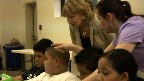 A donor watches the children work
